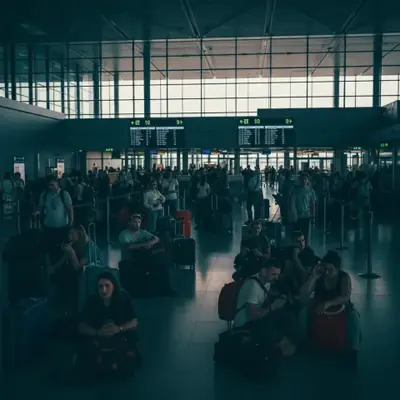 Pasajeros esperando en terminal con paneles apagados