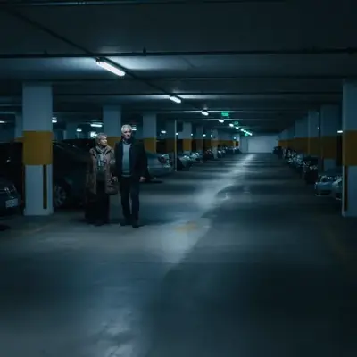 Persona junto a vehículo en parking subterraneo